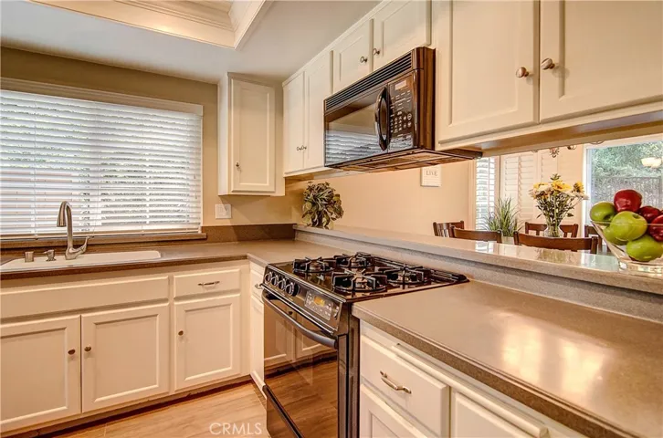 The Definition of Your Dream Kitchen: Solid Surface Counters, Crisp White Cabinets, and Sleek, Newer Appliances!