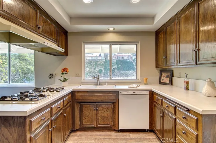 Bright kitchen has plenty of prep space and rich wood cabinetry...plus lovely hillside views.