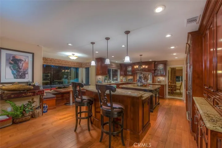 A huge two island kitchen built for a chef with up-graded Dacor appliances, custom cherry wood cabinets with inside and over granite counters,  Built-in Subzero refrigerator, Two additional drawer refrigerators, two convection ovens, microwave, a double drawer Fisher Paykel dishwasher, and Miele Espresso system..