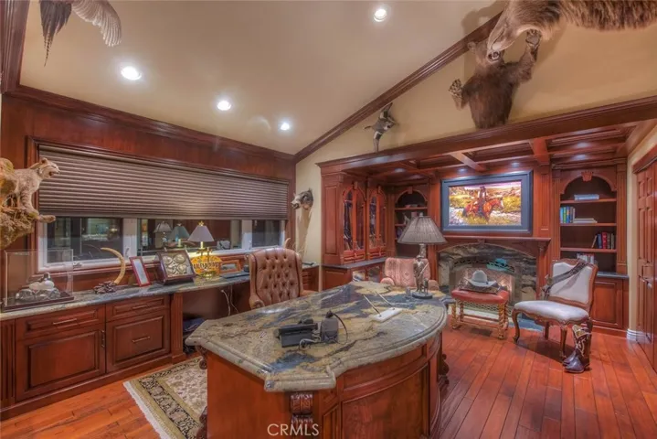 Custom made desk with Granite top is the main focal point of this magnificent office.  The fireplace front has the matching granite and the oil painting over the fireplace rolls up to expose a TV.  Blinds are electronically operated. One of the homes 3 Air conditioners is dedicated solely to this office.