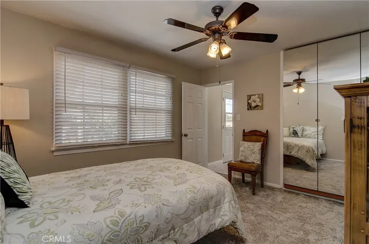 2 inch  blinds, fan with light, and mirrored wardrobes grace bedroom #2.