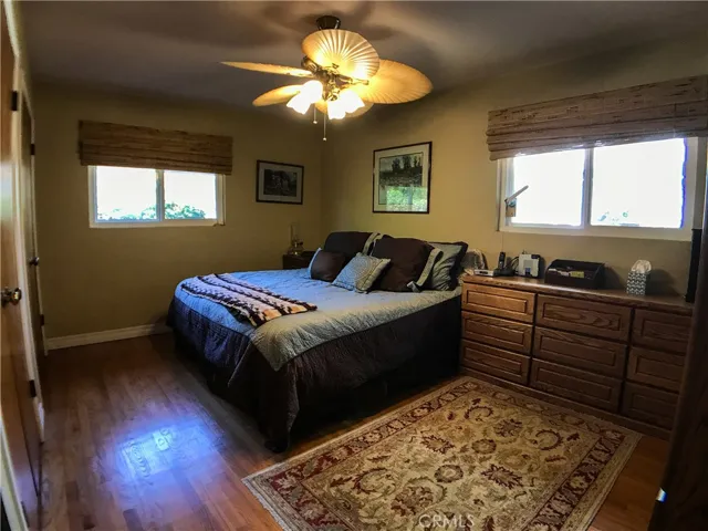 Master bedroom with ceiling fan and two separate closets.