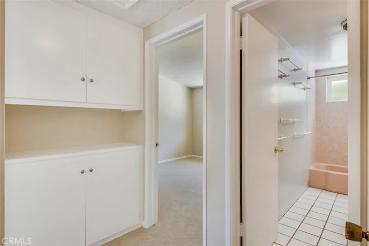 Hallway connects two bedrooms to linen closet and full hall bathroom.