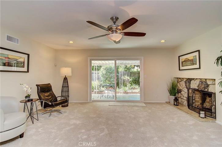 Huge living room is the perfect gathering space with cozy stone fireplace and slider to covered patio and rear yard.