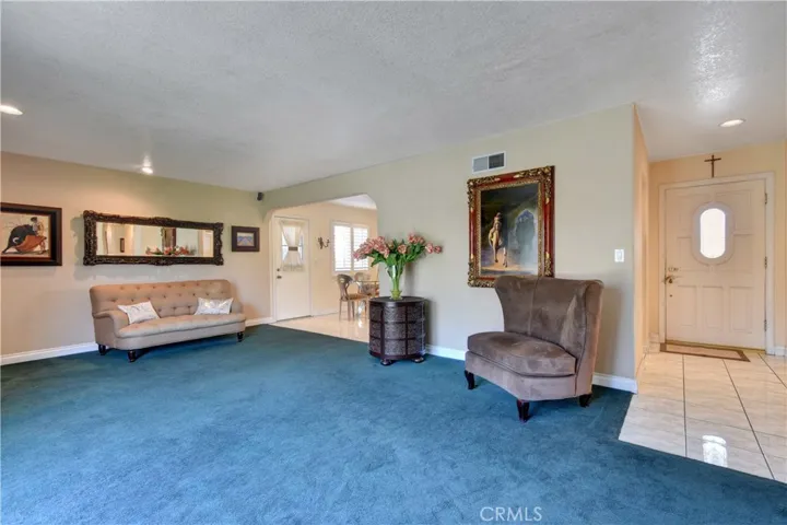 View of living room with scraped ceiling and recessed lights