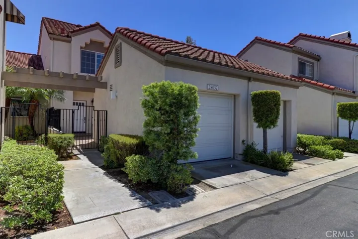 Exterior of the condo showing the one car garage and the gate to the private patio.