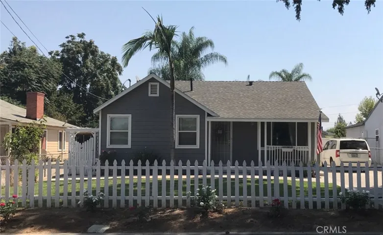 Front view with white picket fence.