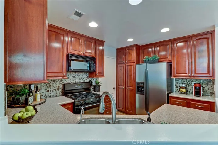 Newer quartz counters, 5-burner gas range, sink, faucet, backsplash, wood laminate flooring and remodeled cabinets.