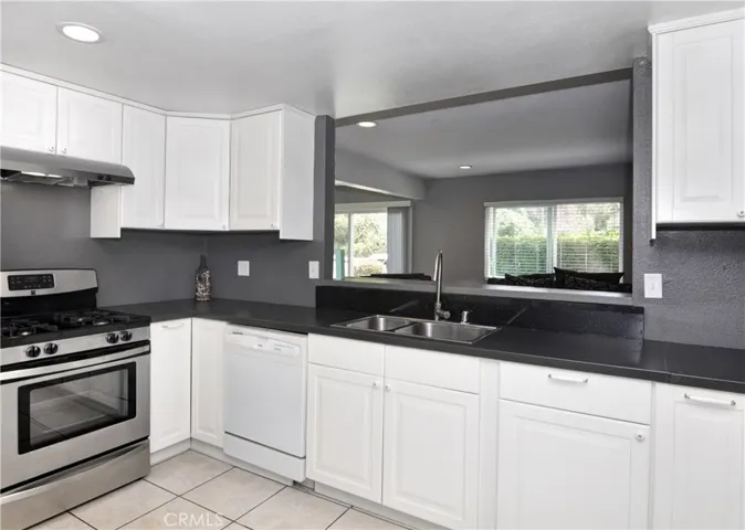 From this angle you see the newer stove and the window from the Kitchen that leads out to the Living Room.