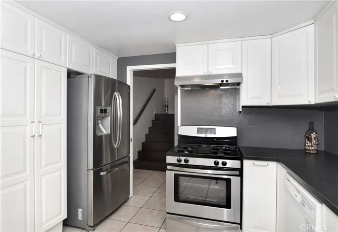 From this angle you see the gorgeous Cabinetry, Recessed Lighting, Tile Flooring, and Wood Laminate Stairs that lead to the upstairs Bedrooms and Bathrooms.