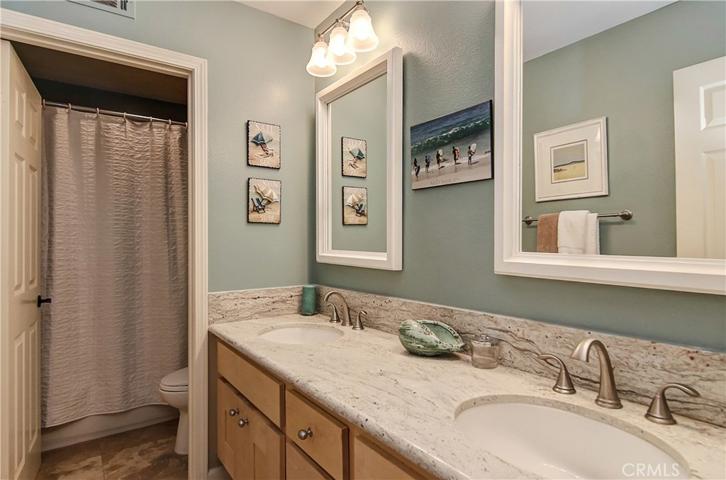 Upstairs hall bath has double sink vanity and separate shower/toilet room.
