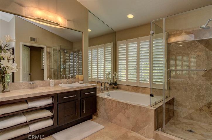 Gorgeous master bath with travertine finishes, huge shower, soaking tub and two separate vanity areas.