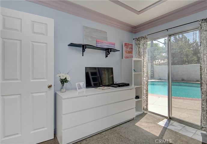 Bright natural light flows in from the big slider in this bedroom that leads out to the backyard/pool.