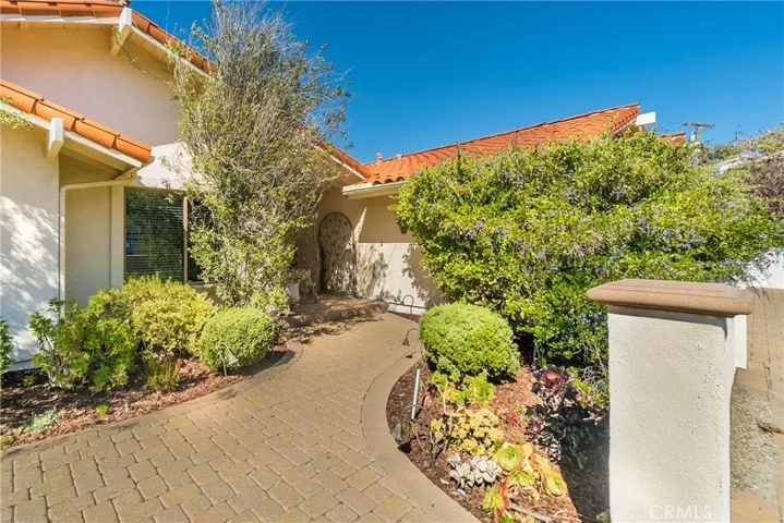Lush landscaping in private courtyard frames the entry to the home.