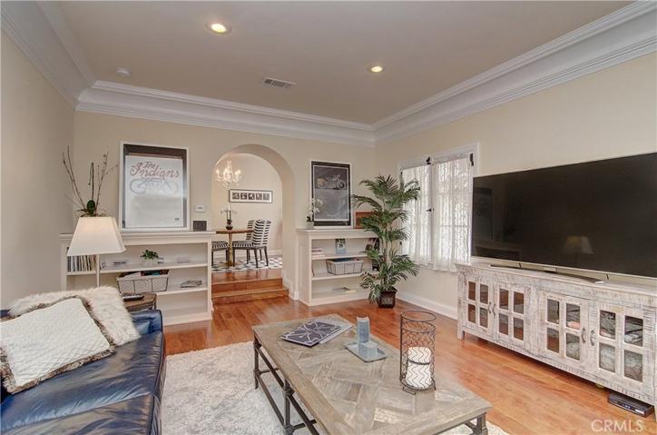 Note lovely built-in shelving and arched detail with steps to dining room.