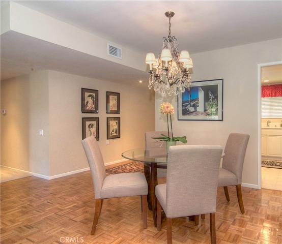 Wood flooring spans throughout dining are and living room, making the space feel open and airy.