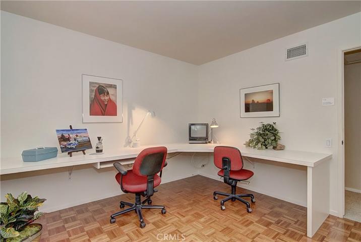 Built-in desk and hardwood flooring: this bedroom us fully utilized and functional.