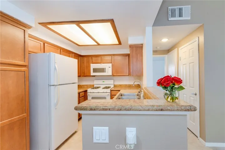 The kitchen has granite countertops, plenty of wood cabinets, and a NEW faucet.