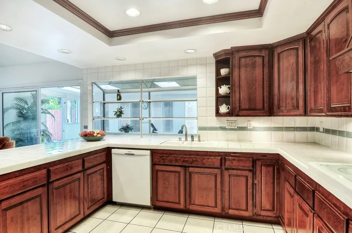 The spacious kitchen just expands as you look through the large greenhouse window and wide sliding glass door. The gym / enclosed patio is just outside with the pool and spa to your left.