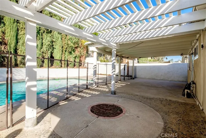 Another view of the backyard with trellis and fire pit.