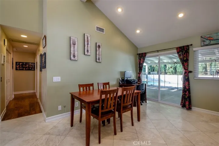 View of the dining area and hallway to bedrooms and baths off of the kitchen.  Also a view of the slider leading to the backyard and pool.