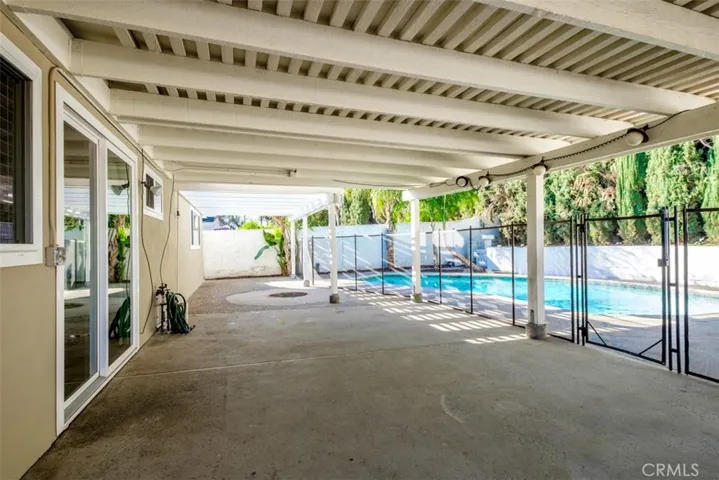 Expansive covered patio area with fenced in pool.