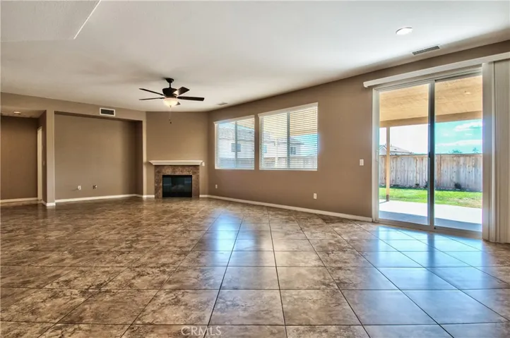 Great room fireplace and media alcove with views to backyard patio.