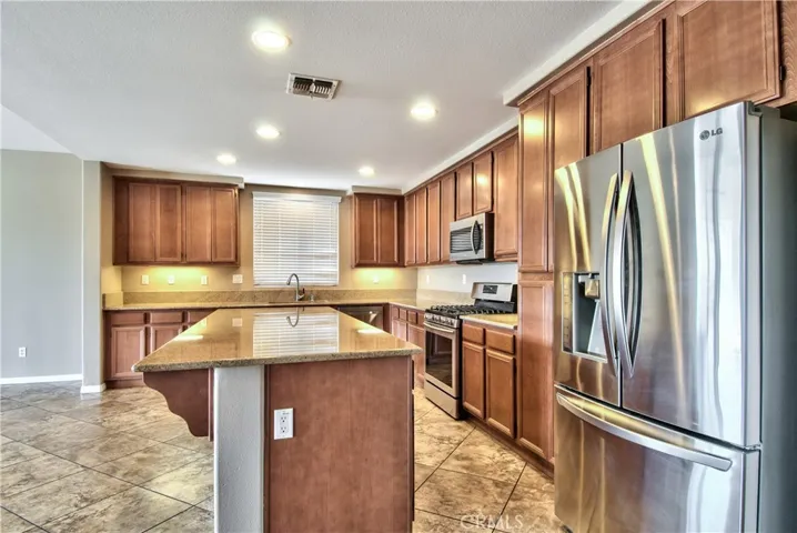 View of kitchen showing appliances and under cabinet lighting.