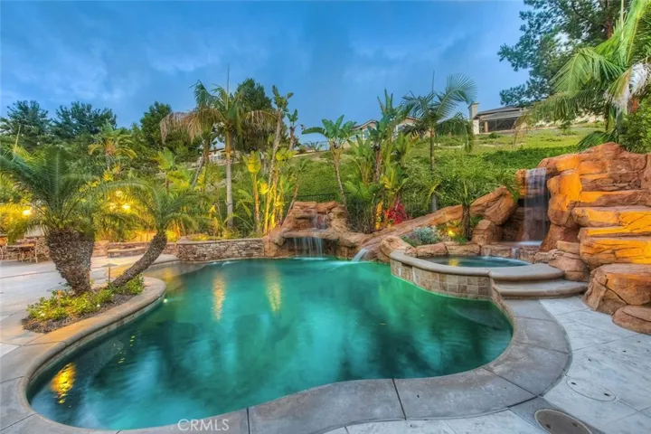 Resort grounds featuring rock design pebble tec salt water pool w/ reef step, 2 waterfalls, water slide, enchanting grotto, firepit, outdoor kitchen, playground and more.