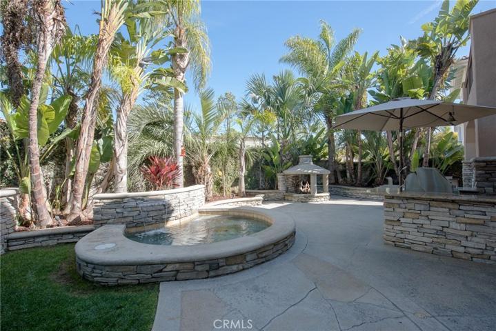 Get the feeling of being on vacation all year round...beautiful pebble tec spa has waterfalls, outdoor kitchen has plenty of room for the gang to hang out during BBQ's...and...LOVE that fireplace!