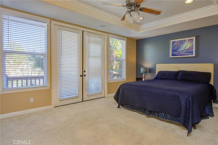 Master French doors open to private balcony overlooking landscaped rear yard.