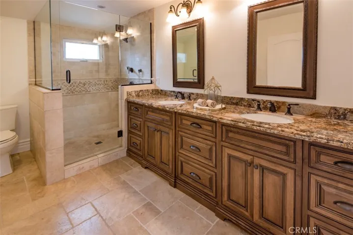 Master Bathroom with dual sinks, granite, custom cabinets and travertine.