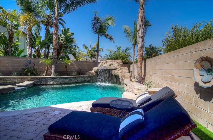 So many nice details....raised stone planters, tropical landscape and pavered lounge area.