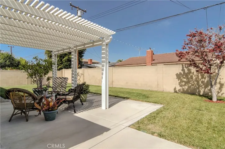 Private rear yard feels huge...plenty of grass for play and fun, plus nice covered patio area for entertaining...trellis is metal...no termites here...never!