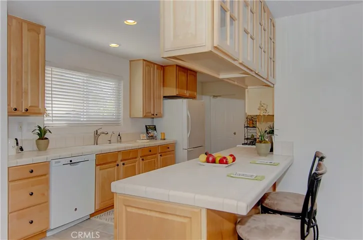 Awesome kitchen with loads of wood cabinetry and prep space...bar area is the perfect spot for homework, or just hanging out with the cook!