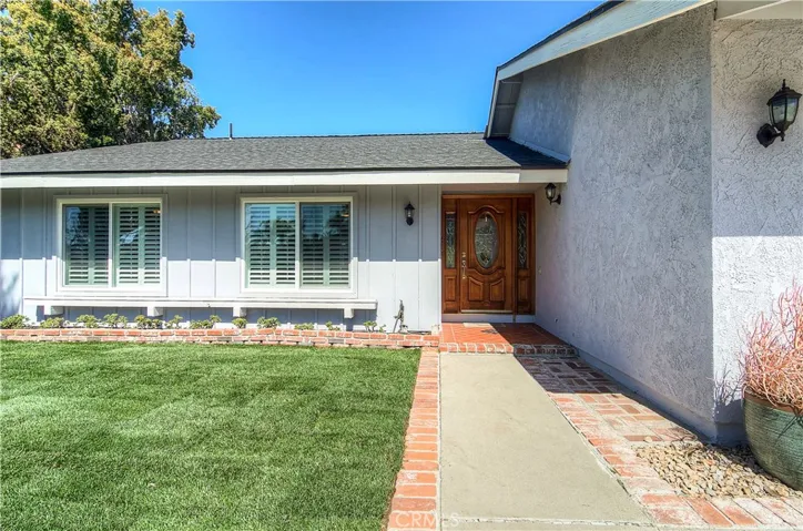 Fresh lawn is framed by brick accents and lovely front door with leaded glass and sidelights creates a nice welcome.