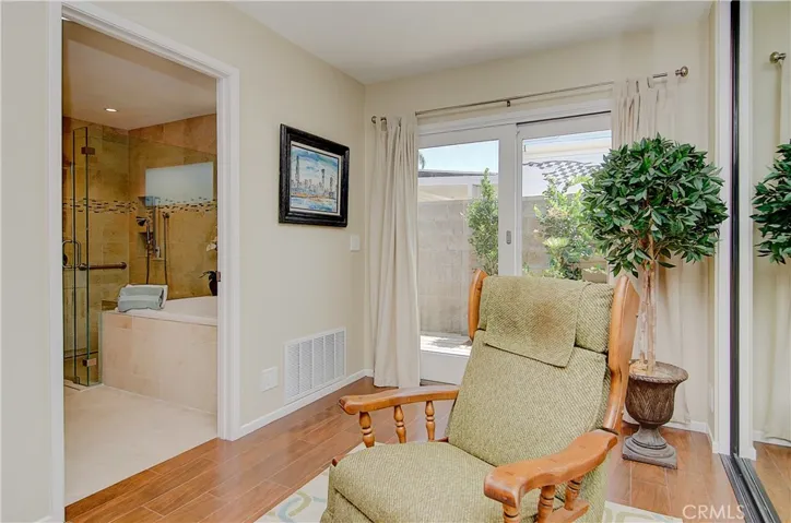 Master offers separate sitting area and slider to private garden area with deck.