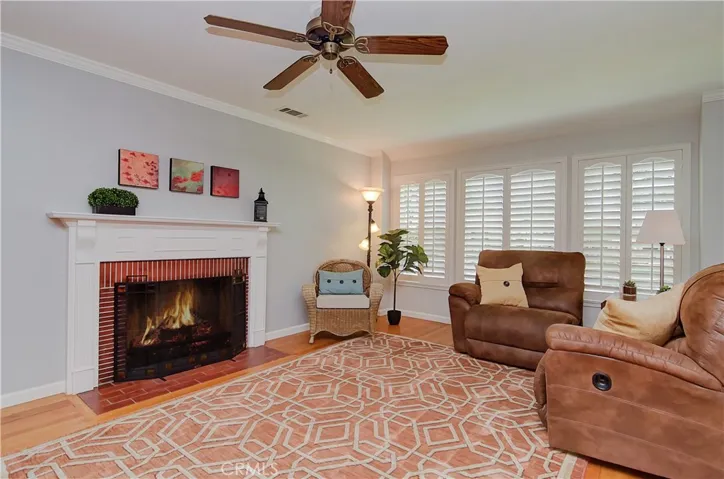 Living Room features ceiling fan, fireplace, bay windows overlooking the neighborhood, and beautiful molding.