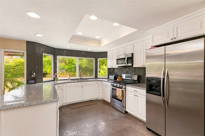 Beautifully remodeled kitchen with granite counter tops, newer stainless steel appliances, Stone flooring, canned lights.