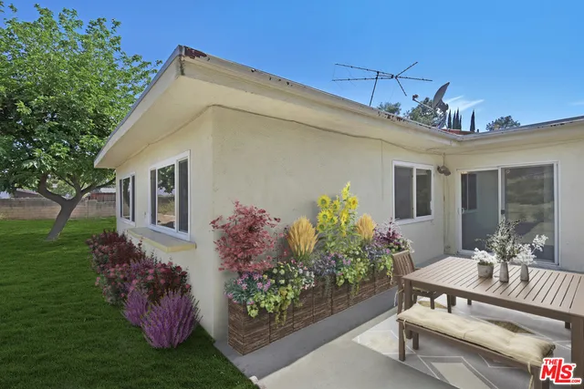 Virtually staged planters and furniture on patio.