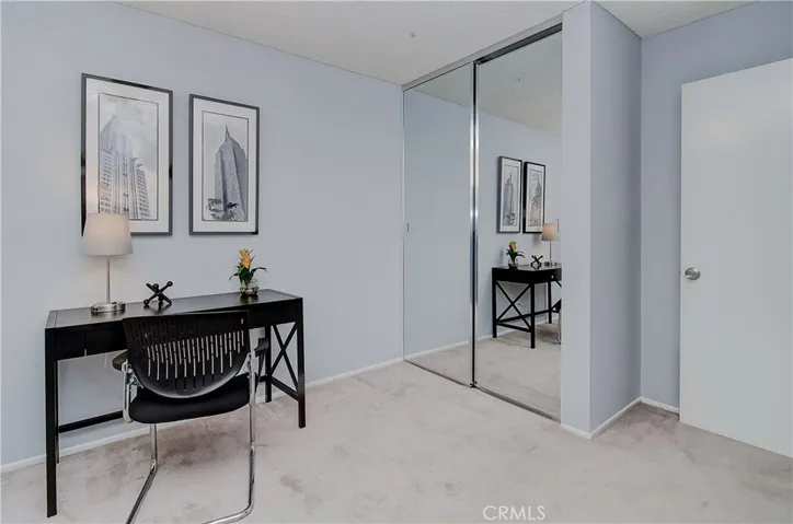 Mirrored doors on large wardrobe closet make the room feel even larger.