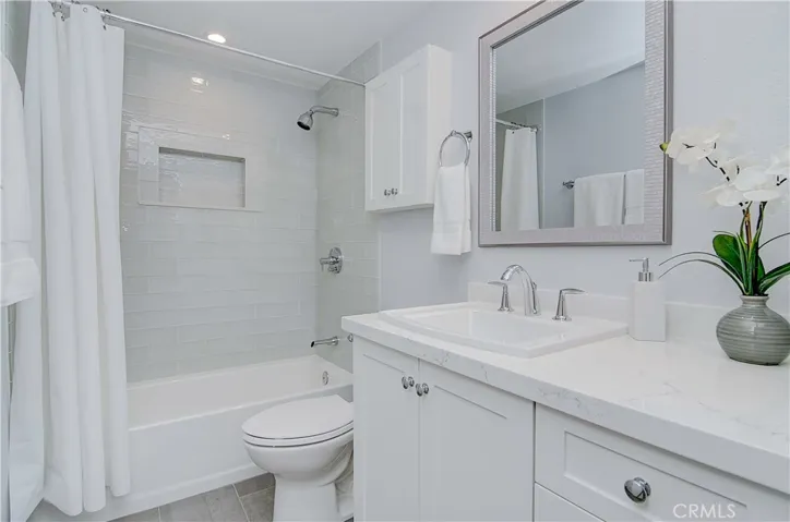 Gleaming hall bath has large vanity with storage, quartz counters and more designer details.