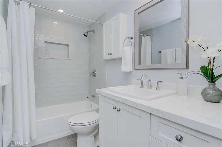 Gleaming hall bath has large vanity with storage, quartz counters and more designer details.
