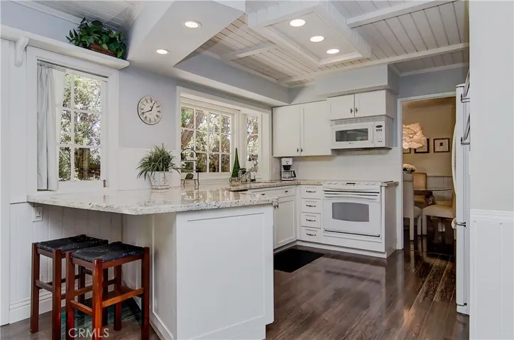 Sunny, remodeled kitchen has beautiful garden window, breakfast bar and is open to family area.