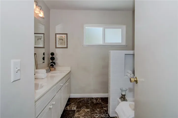 Large hall bath has dual sink vanity.