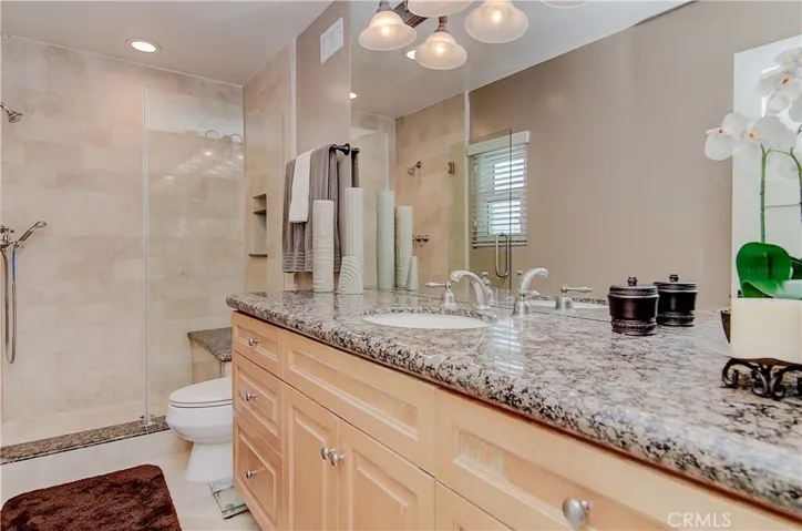 Gorgeous master bath has oversize shower with seat, loads of counter and cabinet space, plus lovely stone and brushed nickel details.