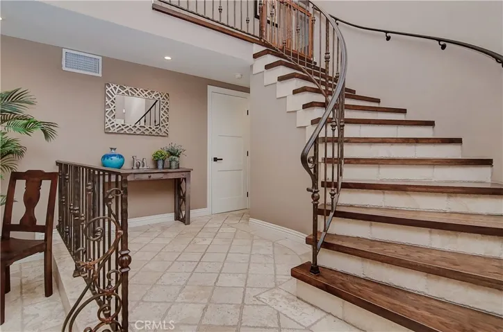 What a great place to greet guests!  Beautiful details with this custom wood and travertine staircase.