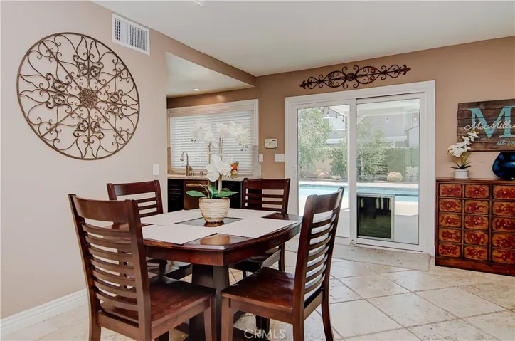 Family room has all you could want...casual dining space, wet bar, slider with pool view...plus the chef is always part of the action here.