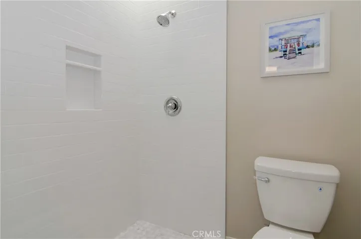 Subway tile shower with chrome finishing and large shampoo cubby.
