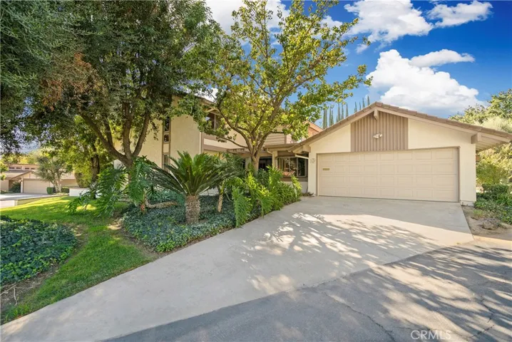 Welcome to Via Dos Cerros. The front landscaping offers privacy, beauty and shade.